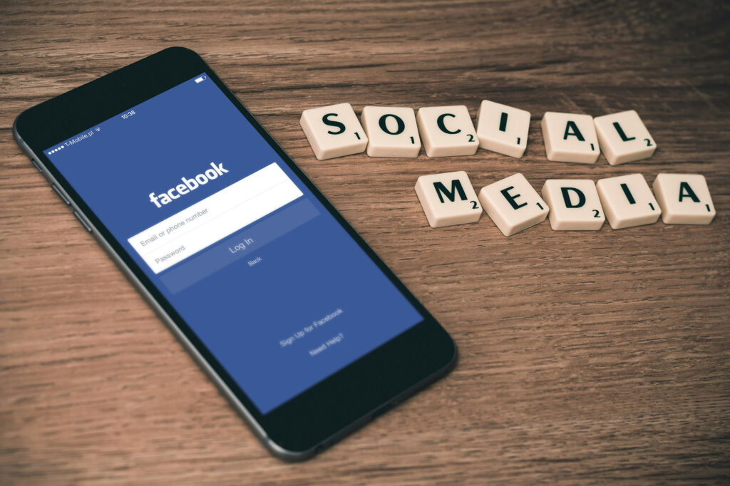 Phone open to facebook and scrabble tiles spelling social media