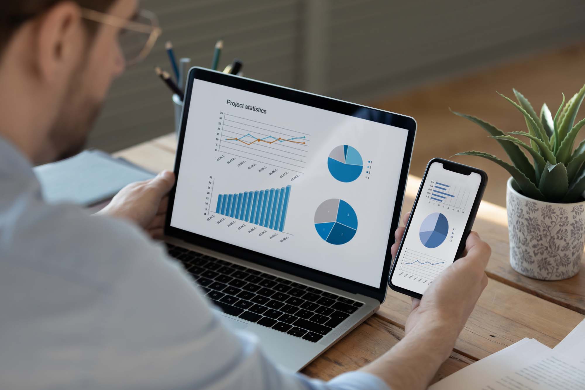 Person looking at statistics on computer and phone