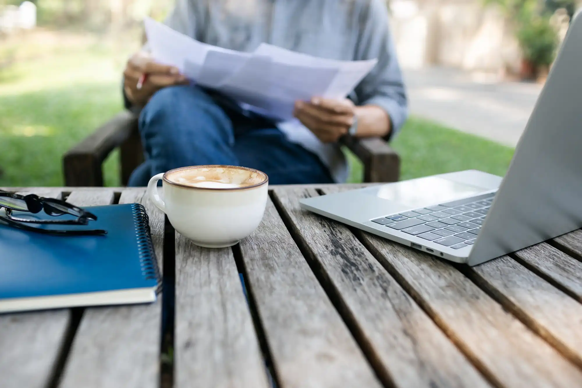 Person working outside with laptop and business papers