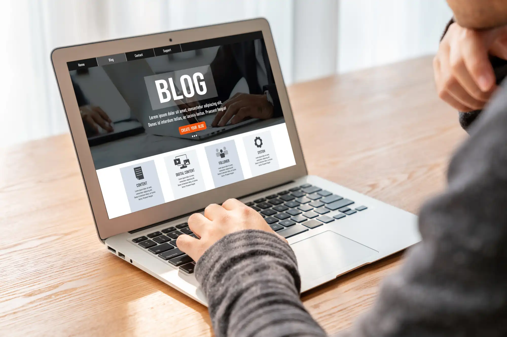 Person writing a blog post on a laptop